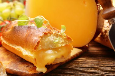 Taze ekmek peynir ve kahverengi antika arka plan üzerinde otlar ile