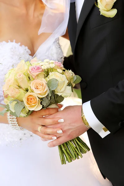 Pareja joven con un ramo de flores y anillos después de la boda —  Fotos de Stock