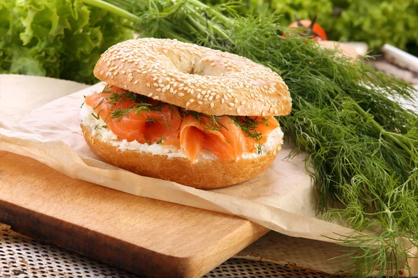 Panino con salmone affumicato e aneto su un tagliere — Foto Stock