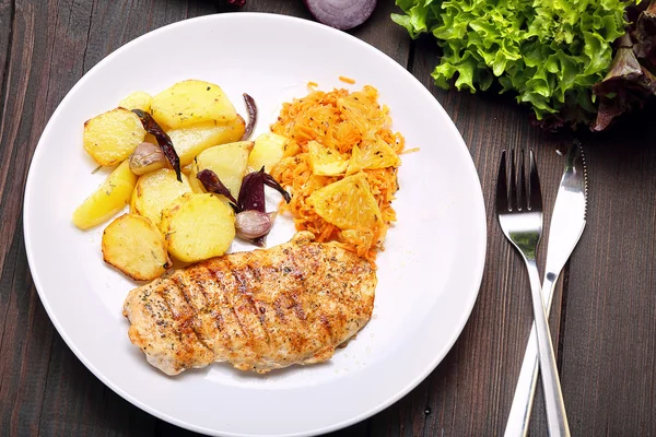 Porción de pollo a la parrilla, papas al horno y ensalada de zanahorias — Foto de Stock