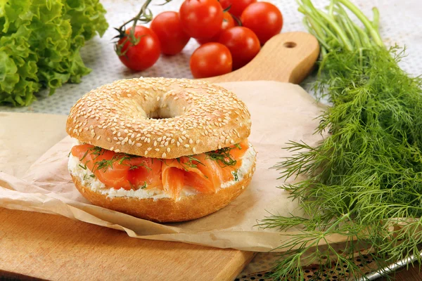 Sandwich with smoked salmon and dill on a chopping board — Stock Photo, Image