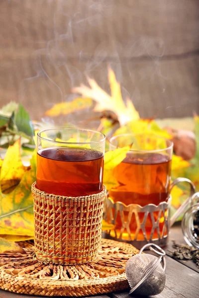 Gorącej herbaty zielonej w szklance na drewniane tła z jesień leav — Zdjęcie stockowe