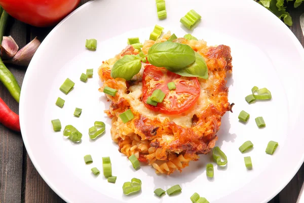 Portion of casserole with tomato and mushrooms on a plate — Stock Photo, Image