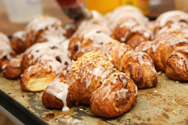 Croissant freschi fuori dal forno e decorati con glassa e wa — Foto Stock