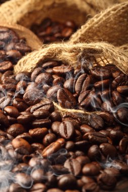 Stüdyo makro sıcak kahve çekirdekleri ile duman topçu yatakta