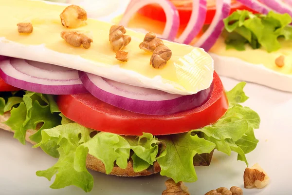 Sandwich con queso brie crema, nueces y verduras sobre blanco — Foto de Stock