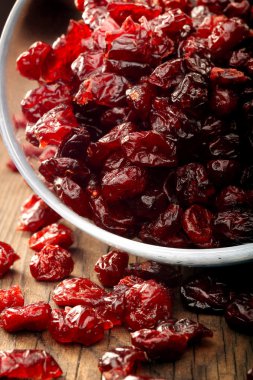 Ahşap arka plan üzerinde bir cam kasede Cranberries kurutulmuş