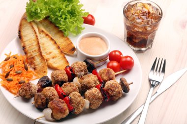 Kıyılmış köfte şişler üzerinde beyaz pla havuç salatası ile olarak pişmiş