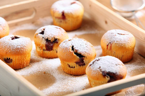 Muffins con mermelada espolvoreado con azúcar en polvo en bandeja de madera —  Fotos de Stock