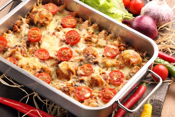 Auflauf mit Reisfrikadellen und Gemüse auf hölzernem Backblech — Stockfoto