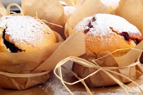 Muffins con mermelada espolvoreado con azúcar en polvo en bandeja de madera —  Fotos de Stock