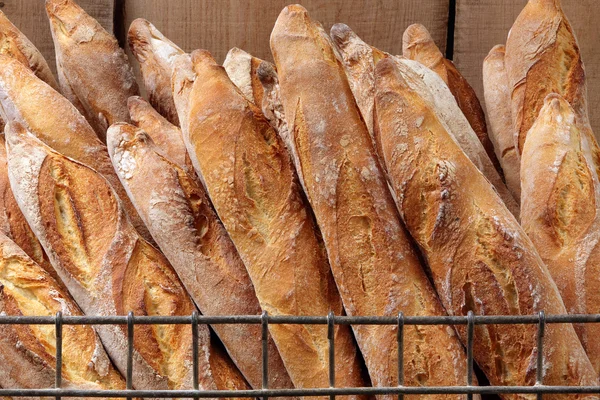 Baguettes franceses en canasta metálica en panadería Imagen De Stock