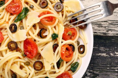 Ahşap zemin üzerine zeytin soslu spagetti