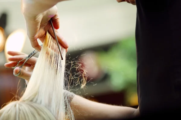 Fryzjer przycinanie blond włosy nożyczkami — Zdjęcie stockowe
