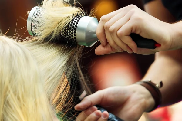 Cabeleireiro pentear o cabelo da jovem por escova de cabelo e cabelo seco — Fotografia de Stock