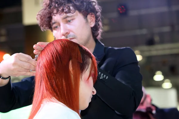 POZNAN - 18 AVRIL : Coiffeur coupe les cheveux roux avec des ciseaux — Photo