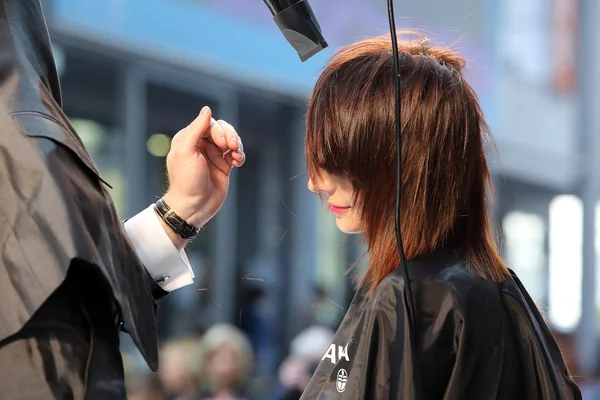 Poznań - 18 kwietnia: Fryzjer modelowanie brązowe włosy z drayer — Zdjęcie stockowe