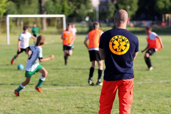 医疗救护员为年轻男孩一场足球比赛的 — 图库照片