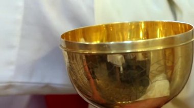 Rahip komünyon kitle sırasında dağıtır.