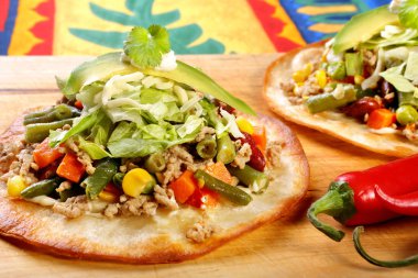 Tostadas kıyma ve ahşap arka plan üzerinde sebze ile