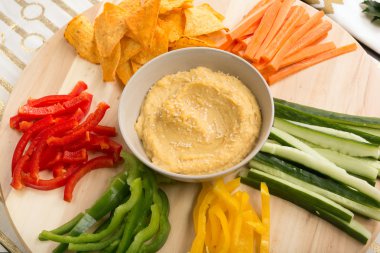 Bir ahşap döner tabloda sebzeli humus