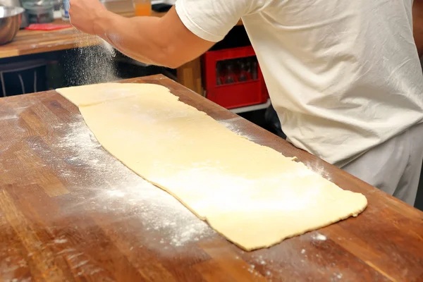 Baker gegoten bloem op de tabel voor rollend deeg — Stockfoto