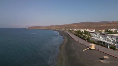 İspanya, Tarajalejo - 06.08.2025: İspanya 'nın Kanarya Adaları, Fuerteventura Adası' nın güney kesimindeki volkanik kıyıların yamaçlarında yer alan Tarajalejo 'daki tatil beldeleri ve gezinti alanları.
