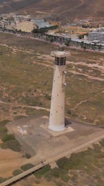 Faro de Morro Jable, Fuerteventura, Kanarya Adaları, İspanya 'nın deniz feneri ve plajının dikey görüntüsü..