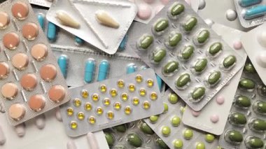 Su toplayan bir pakete yerleştirilmiş farklı hap kapsüllerinin en üst görünümü.