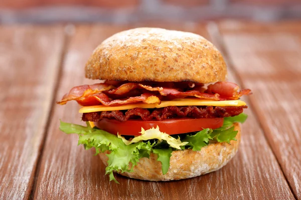 Hamburger di pancetta con pomodoro e formaggio sul tavolo di legno — Foto Stock