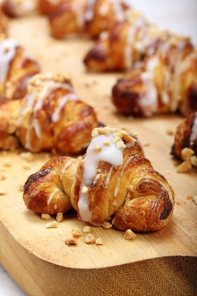 Croissant stuffed with walnuts on wooden background — Stock Photo, Image