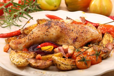 Kavrulmuş Tavuk budu sebze ve otlar üzerinde ahşap backgro