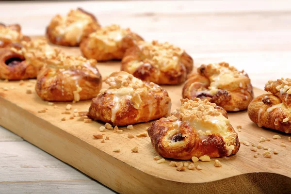 Croissant stuffed jam with walnuts on wooden background — Stock Photo, Image