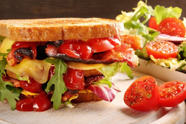 Dubbele sandwich met spek, kaas en groenten op houten backg — Stockfoto