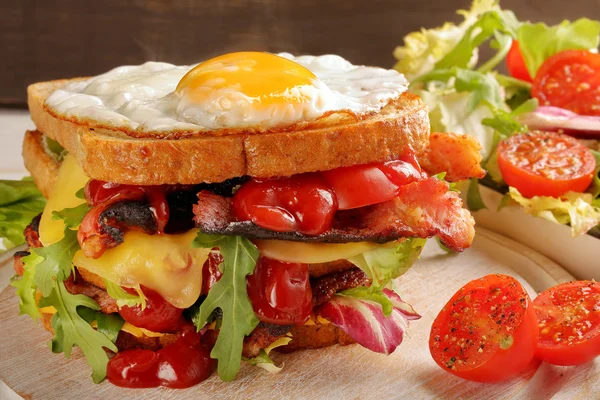 ベーコン チーズ、卵の木製の背景を持つダブル サンドイッチ — ストック写真