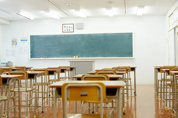 Skolan klassrum med Skolbänkar och blackboard Stockfoto