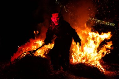 Krampus walking on embers through fire clipart