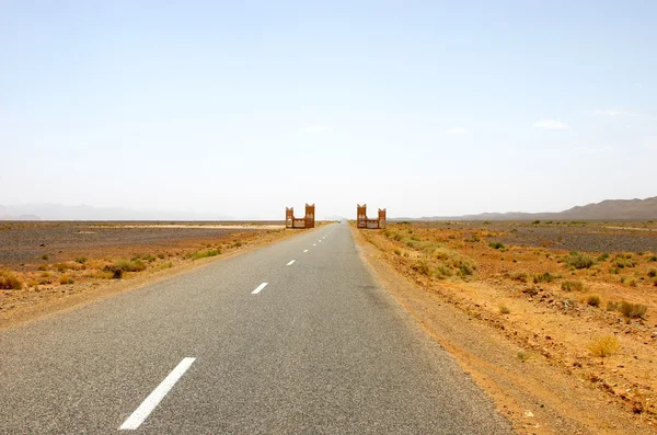 Gerade Straße durch die Wüste lizenzfreie Stockfotos