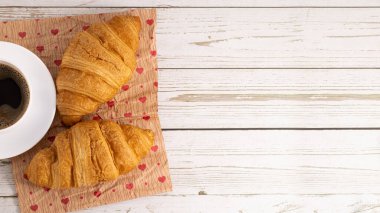 Taze kruvasan ve açık ahşap arka planda fotokopi alanı olan kahve..
