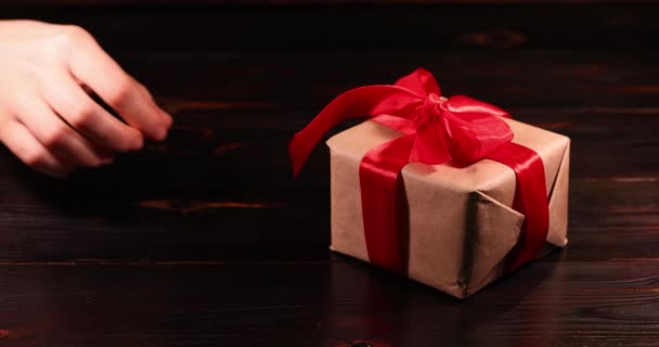Χέρι Της Γυναίκας Λύνει Την Κόκκινη Κορδέλα Στο Κουτί Δώρα — Αρχείο Βίντεο