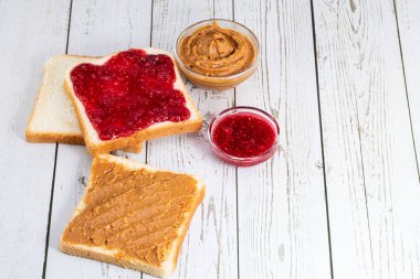 Fıstık ezmeli tost ve böğürtlen reçeli açık tahta arka planda fotokopi alanı ile. Üst görünüm.