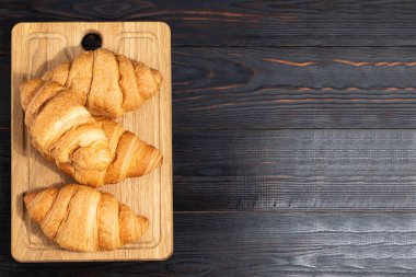 Tahtada fotokopi alanı olan taze kruvasanlar. Üst görünüm.