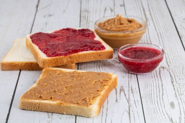 Fıstık ezmeli tost ve hafif ahşap arka planda çilek reçeli.. 