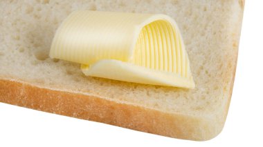 Beyaz arka planda tereyağı kıvrımlı ekmek dilimi.