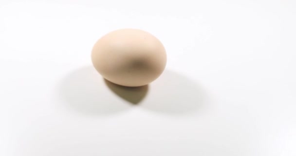 鸡蛋在白色的背景上旋转 慢动作 — 图库视频影像