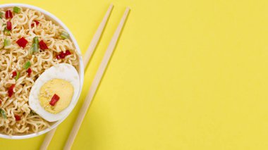 Sebzeli erişte ve çanakta yumurta. Arka planda sarı arka planda fotokopi alanlarıyla birlikte..