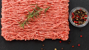 Koyu arka planda çiğ et ve baharatlar..