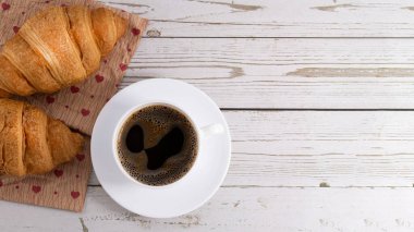 Taze kruvasan ve açık ahşap arka planda fotokopi alanı olan kahve..