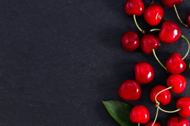 Koyu arkaplanda fotokopi alanı olan bir kiraz. Üst Manzara. Düz yatıyordu.