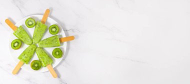 Kasede dondurulmuş kivi suyu. Çubukta buzlu şeker. Üst görünüm, alanı kopyala.